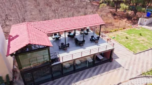 Guests enjoying breakfast in the open-air restaurant at Mountail Eco Resort with misty hills in the background.